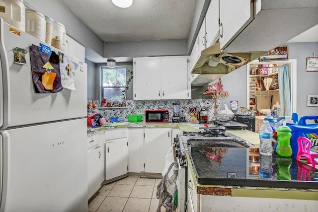 8505 Dryfield Dr, Austin, TX 78758 - kitchen with freestanding refrigerator, range with gas stovetop, white cabinetry, and a textured ceiling