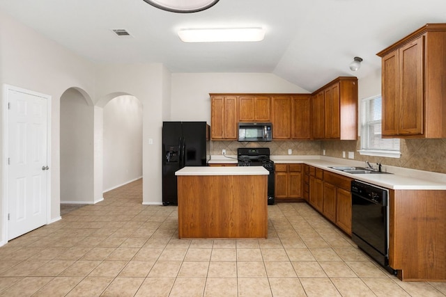117 N Maplewood, Kyle, TX 78640 - kitchen with black appliances, decorative backsplash, brown cabinetry, a kitchen island, and lofted ceiling