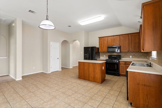 117 N Maplewood, Kyle, TX 78640 - kitchen with black appliances, a kitchen island, arched walkways, light countertops, and brown cabinetry
