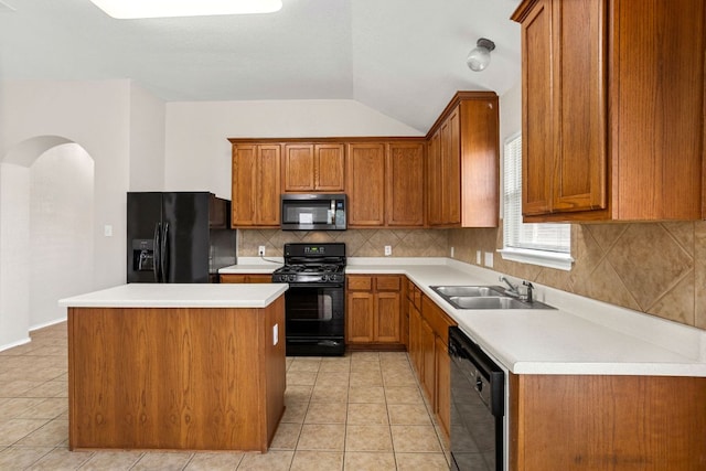 117 N Maplewood, Kyle, TX 78640 - kitchen featuring black appliances, a center island, lofted ceiling, brown cabinets, and tasteful backsplash