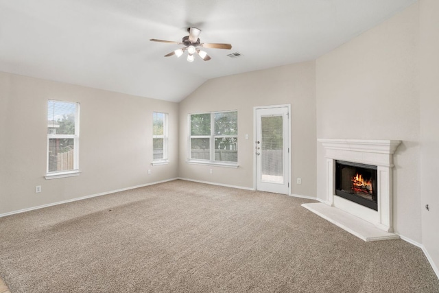 117 N Maplewood, Kyle, TX 78640 - unfurnished living room featuring ceiling fan, carpet floors, a warm lit fireplace, and vaulted ceiling