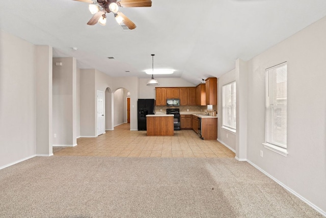 117 N Maplewood, Kyle, TX 78640 - kitchen with black appliances, open floor plan, brown cabinets, light countertops, and light carpet