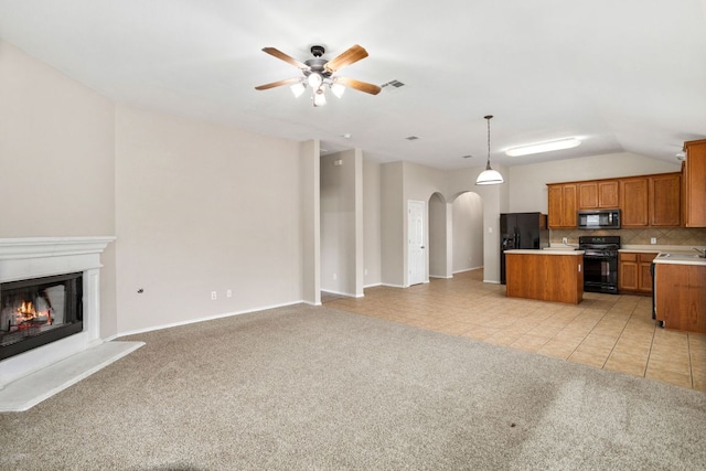 117 N Maplewood, Kyle, TX 78640 - kitchen with black appliances, open floor plan, arched walkways, light carpet, and a ceiling fan