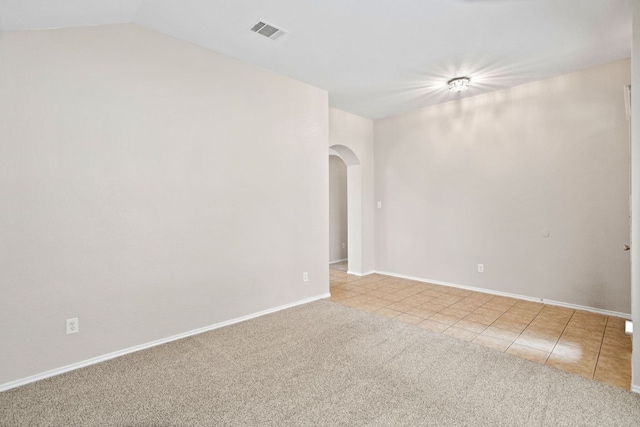 117 N Maplewood, Kyle, TX 78640 - carpeted empty room with arched walkways, tile patterned floors, and vaulted ceiling