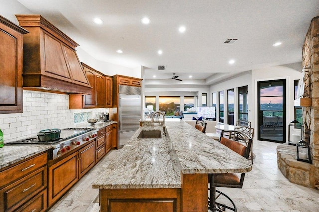 921 Electra, Lakeway, TX 78734 - kitchen featuring stainless steel appliances, a sink, a kitchen bar, tasteful backsplash, and a large island with sink