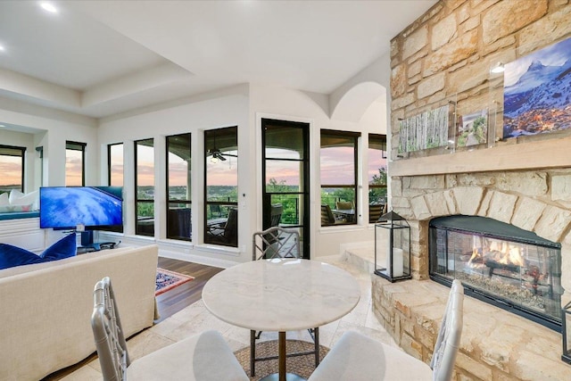 921 Electra, Lakeway, TX 78734 - dining area with an outdoor stone fireplace, a ceiling fan, and a raised ceiling