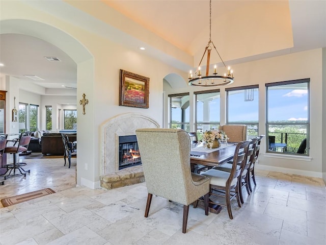 921 Electra, Lakeway, TX 78734 - dining room featuring stone tile flooring, arched walkways, a fireplace, baseboards, and recessed lighting