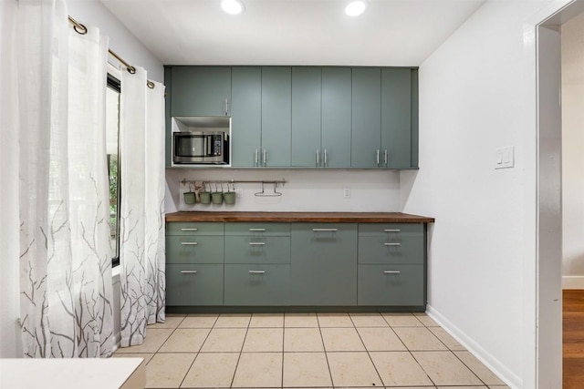 1506 Northridge Dr, Austin, TX 78723 - kitchen with stainless steel microwave, wooden counters, recessed lighting, baseboards, and light tile patterned floors