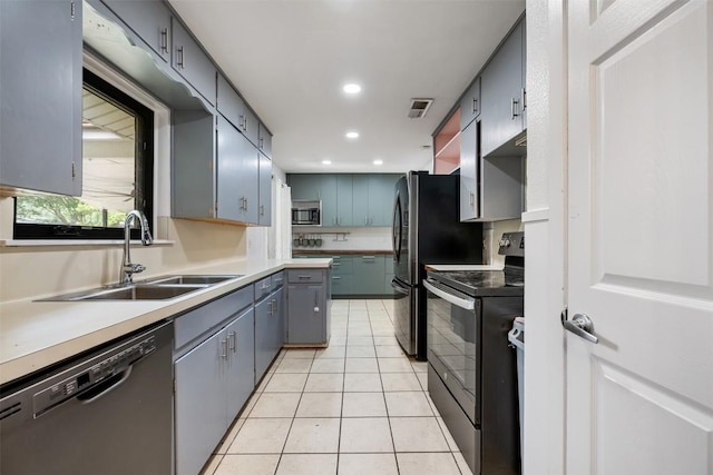 1506 Northridge Dr, Austin, TX 78723 - kitchen with appliances with stainless steel finishes, a sink, light tile patterned flooring, recessed lighting, and gray cabinetry
