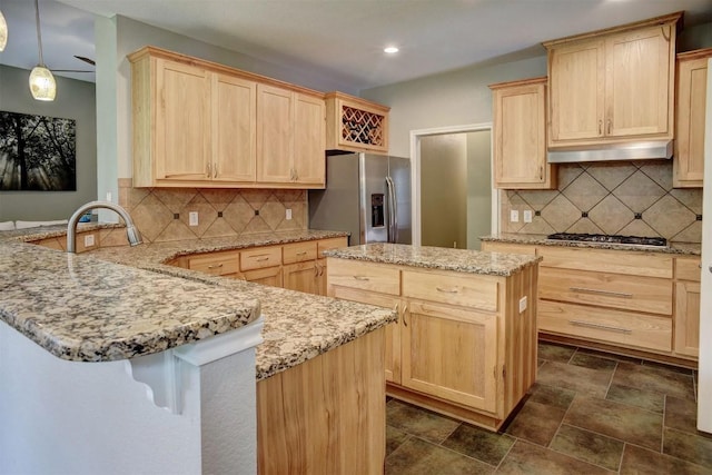 233 Maple Leaf Trl, Elgin, TX 78621 - kitchen featuring light brown cabinets, appliances with stainless steel finishes, a peninsula, light stone countertops, and recessed lighting