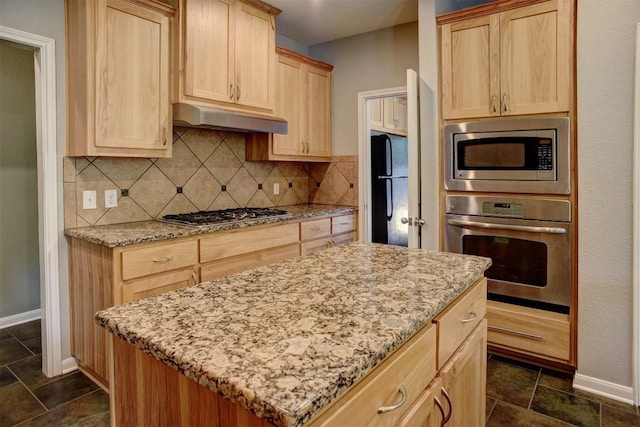 233 Maple Leaf Trl, Elgin, TX 78621 - kitchen with appliances with stainless steel finishes, under cabinet range hood, light brown cabinetry, baseboards, and decorative backsplash