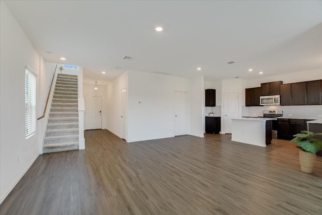 561 Greatest Gift Way, Jarrell, TX 76537 - unfurnished living room with wood finished floors, stairs, baseboards, and recessed lighting