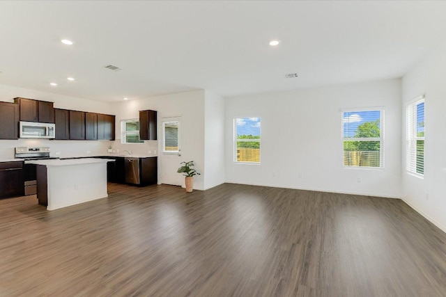 561 Greatest Gift Way, Jarrell, TX 76537 - kitchen featuring stainless steel appliances, light countertops, dark brown cabinets, dark wood-style flooring, and recessed lighting