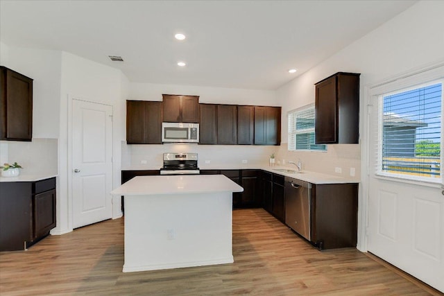 561 Greatest Gift Way, Jarrell, TX 76537 - kitchen with stainless steel appliances, a sink, decorative backsplash, a center island, and dark brown cabinetry