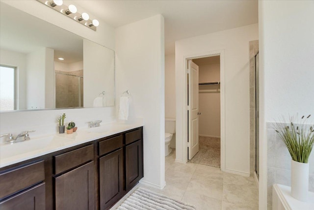 561 Greatest Gift Way, Jarrell, TX 76537 - bathroom featuring toilet, a stall shower, double vanity, and a walk in closet