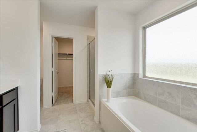 561 Greatest Gift Way, Jarrell, TX 76537 - full bath with a shower stall, a bath, vanity, a walk in closet, and tile patterned flooring
