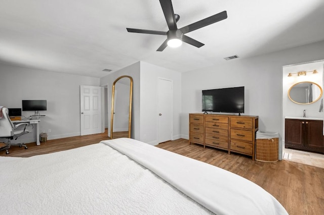 7607 Whispering Winds Dr, Austin, TX 78745 - bedroom featuring wood finished floors, an office area, ensuite bathroom, baseboards, and ceiling fan