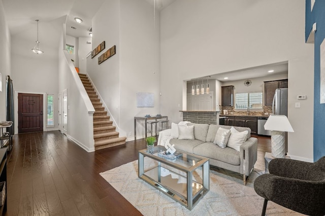 2101 Rivers Edge Way Unit 9, Austin, TX 78741 - living room featuring a high ceiling, baseboards, dark wood-style floors, and stairs