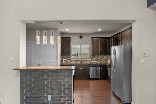 2101 Rivers Edge Way Unit 9, Austin, TX 78741 - kitchen featuring stainless steel appliances, dark brown cabinetry, backsplash, dark wood-style floors, and stone counters