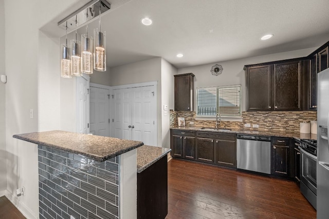 2101 Rivers Edge Way Unit 9, Austin, TX 78741 - kitchen featuring stainless steel appliances, a sink, dark brown cabinetry, dark wood finished floors, and tasteful backsplash