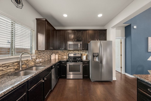 2101 Rivers Edge Way Unit 9, Austin, TX 78741 - kitchen with stainless steel appliances, a sink, decorative backsplash, dark wood finished floors, and dark stone countertops
