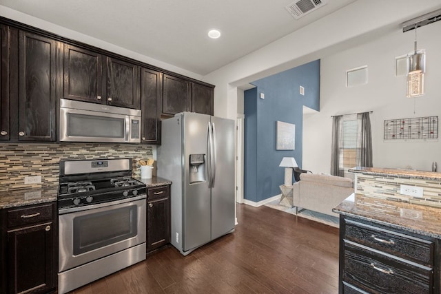 2101 Rivers Edge Way Unit 9, Austin, TX 78741 - kitchen featuring stainless steel appliances, dark stone countertops, backsplash, dark wood-type flooring, and open floor plan