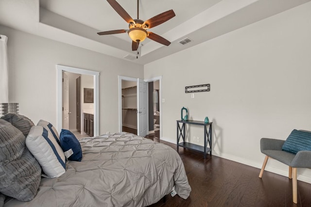 2101 Rivers Edge Way Unit 9, Austin, TX 78741 - bedroom with a raised ceiling, wood finished floors, baseboards, a spacious closet, and connected bathroom