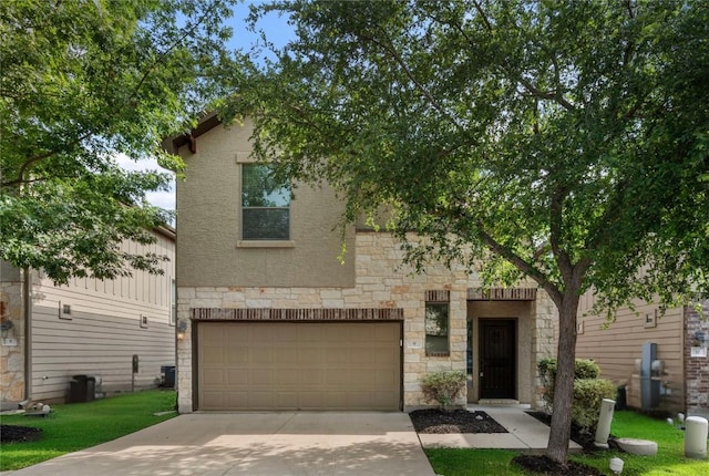 2101 Rivers Edge Way Unit 9, Austin, TX 78741 - view of front facade featuring stone siding, an attached garage, concrete driveway, stucco siding, and a front yard