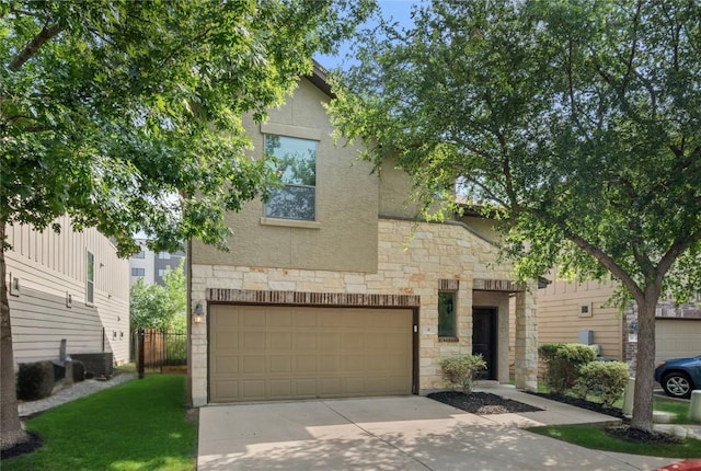 2101 Rivers Edge Way Unit 9, Austin, TX 78741 - view of front of house featuring stone siding, concrete driveway, a garage, and stucco siding