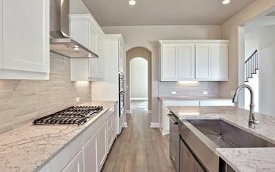 4720 Napoli Shore Dr, Leander, TX 78641 - kitchen with stainless steel appliances, wall chimney exhaust hood, white cabinetry, light stone counters, and light wood-type flooring