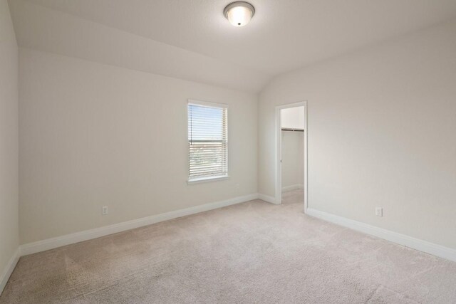 7109 Bargello Pl, Round Rock, TX 78665 - unfurnished bedroom with light carpet, a spacious closet, vaulted ceiling, and a closet