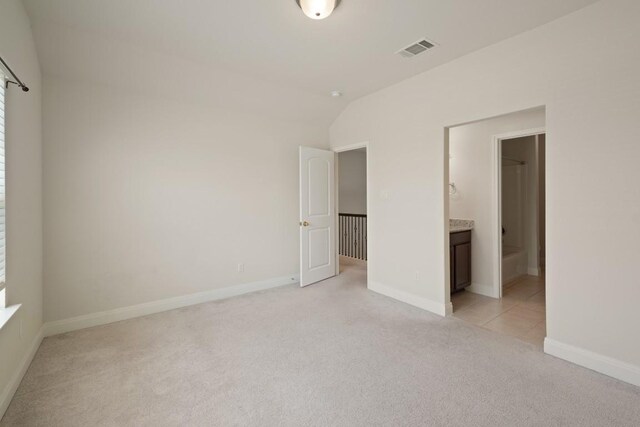 7109 Bargello Pl, Round Rock, TX 78665 - unfurnished bedroom with light colored carpet, lofted ceiling, and connected bathroom