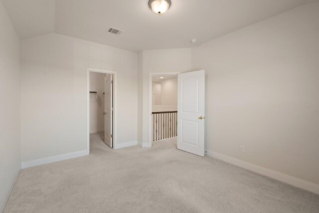 7109 Bargello Pl, Round Rock, TX 78665 - unfurnished bedroom with light colored carpet, a walk in closet, vaulted ceiling, and a closet