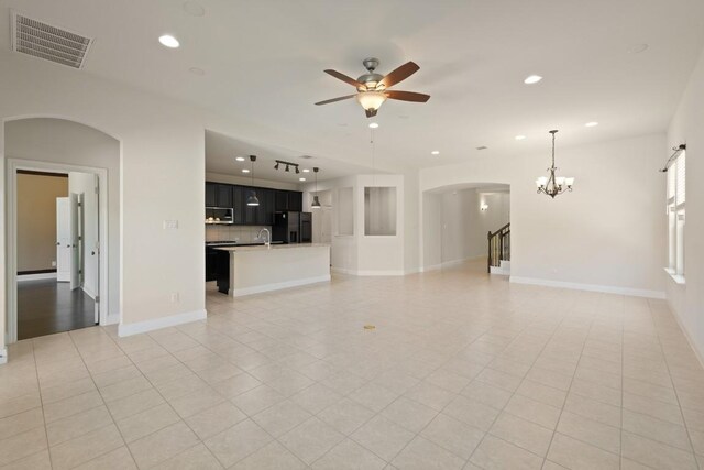 7109 Bargello Pl, Round Rock, TX 78665 - unfurnished living room featuring arched walkways, ceiling fan, a chandelier, recessed lighting, and light tile patterned floors