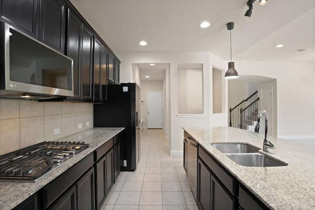 7109 Bargello Pl, Round Rock, TX 78665 - kitchen with appliances with stainless steel finishes, a sink, dark cabinets, decorative light fixtures, and decorative backsplash