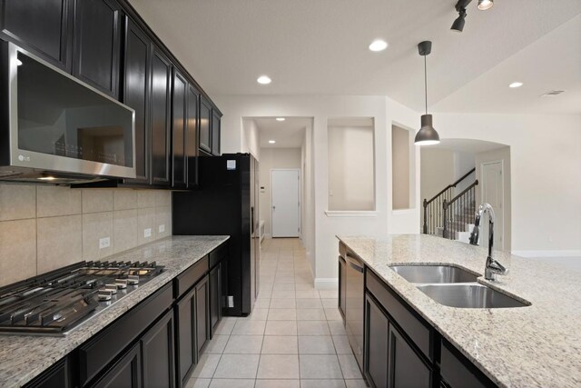 7109 Bargello Pl, Round Rock, TX 78665 - kitchen featuring stainless steel appliances, dark cabinetry, decorative light fixtures, tasteful backsplash, and light tile patterned floors