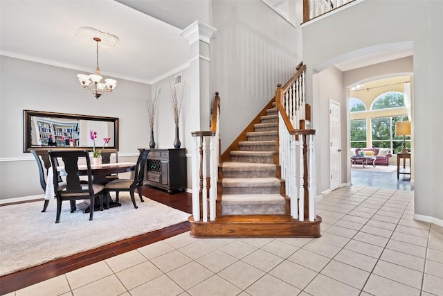 10129 Brimfield Dr, Austin, TX 78726 - entryway featuring light tile patterned floors, stairs, a chandelier, arched walkways, and baseboards