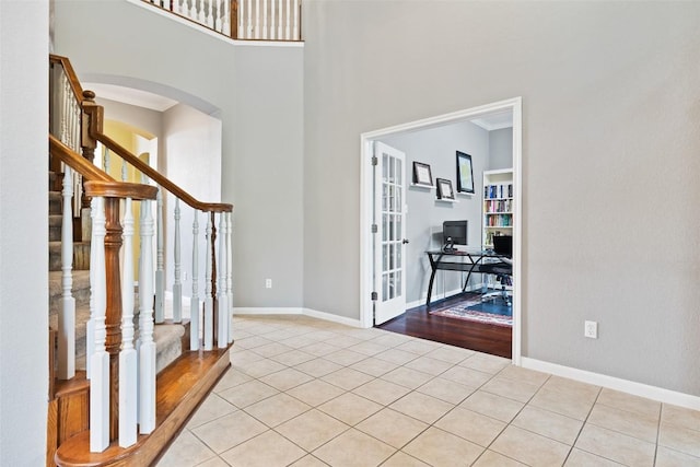 10129 Brimfield Dr, Austin, TX 78726 - foyer with stairs, arched walkways, french doors, light tile patterned flooring, and baseboards
