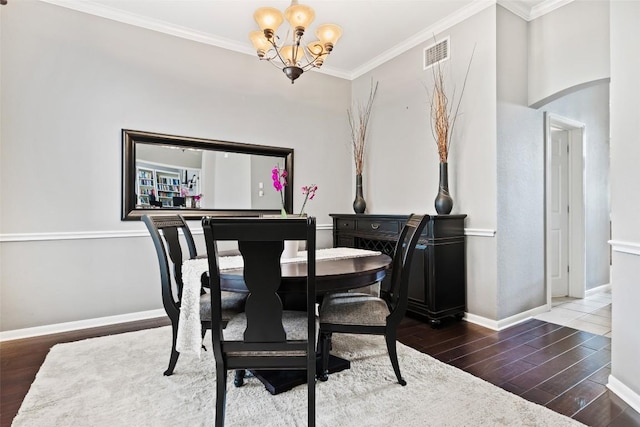 10129 Brimfield Dr, Austin, TX 78726 - dining room featuring a chandelier, wood finished floors, crown molding, baseboards, and arched walkways
