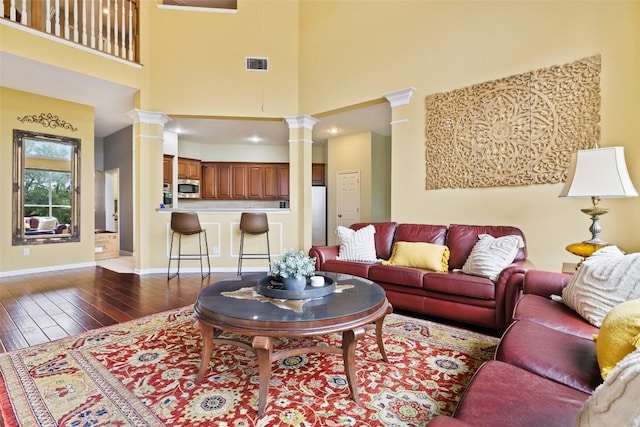 10129 Brimfield Dr, Austin, TX 78726 - living room with decorative columns, wood finished floors, a high ceiling, and baseboards
