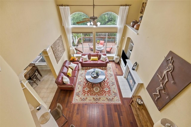 10129 Brimfield Dr, Austin, TX 78726 - living area featuring a fireplace, a high ceiling, ceiling fan, and hardwood / wood-style floors