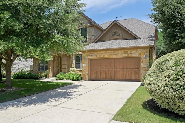 12404 Montclair Bnd, Austin, TX 78732 - view of front of property with stone siding, an attached garage, roof with shingles, concrete driveway, and a front yard