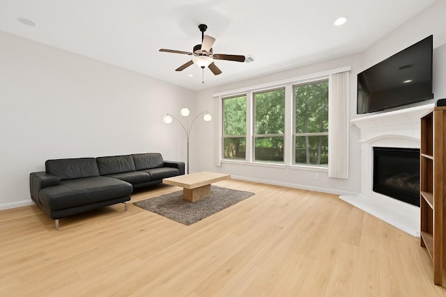 12404 Montclair Bnd, Austin, TX 78732 - living room with light wood-type flooring, ceiling fan, a glass covered fireplace, baseboards, and recessed lighting