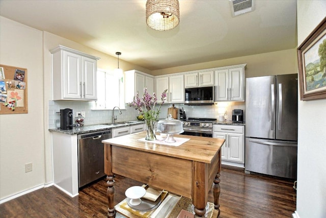 510 W Metcalfe St, Hutto, TX 78634 - kitchen featuring stainless steel appliances, white cabinets, a sink, dark wood-type flooring, and butcher block counters