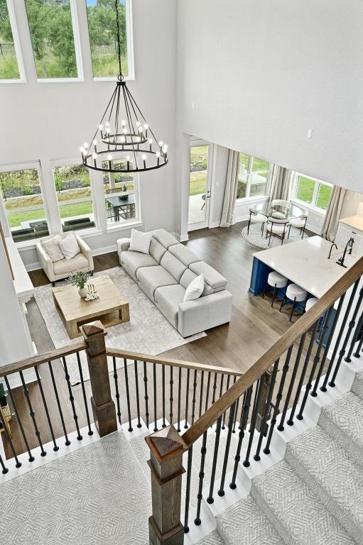 467 Cortaro Dr, Dripping Springs, TX 78620 - living room with a high ceiling, a chandelier, wood finished floors, and stairway