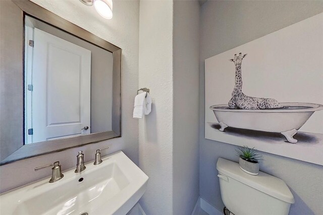 467 Cortaro Dr, Dripping Springs, TX 78620 - bathroom with a sink, toilet, and baseboards