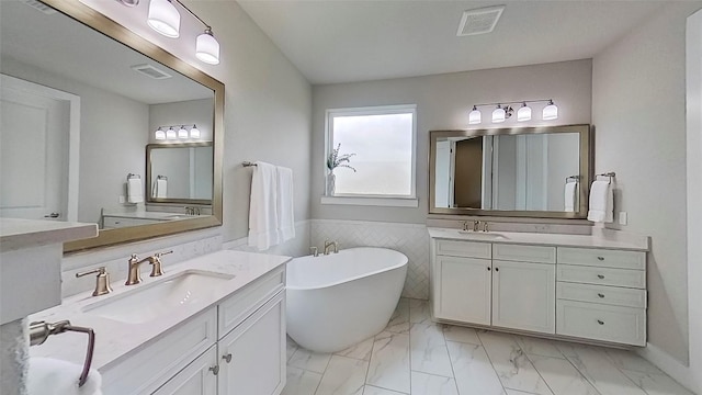 467 Cortaro Dr, Dripping Springs, TX 78620 - full bathroom featuring two vanities, a freestanding bath, and marble finish flooring