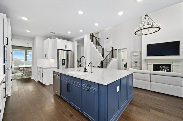 467 Cortaro Dr, Dripping Springs, TX 78620 - kitchen with appliances with stainless steel finishes, a sink, blue cabinetry, dark wood-style flooring, and recessed lighting