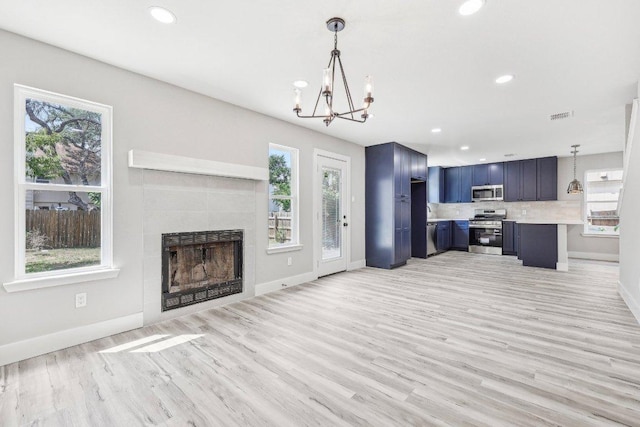 8804 Ravello Pass, Austin, TX 78749 - kitchen featuring stainless steel appliances, light countertops, a chandelier, baseboards, and blue cabinetry
