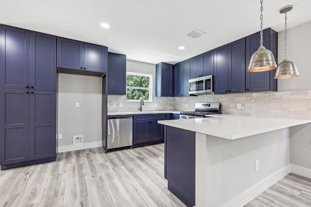 8804 Ravello Pass, Austin, TX 78749 - kitchen featuring stainless steel appliances, a peninsula, light wood-style flooring, light countertops, and decorative backsplash